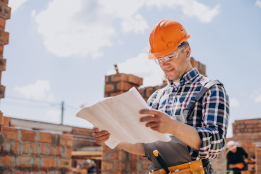 Young craftsman building a house